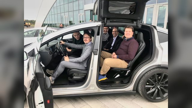 Vincenzo Punzo and research colleagues seated inside and beside an open test vehicle at ZalaZONE