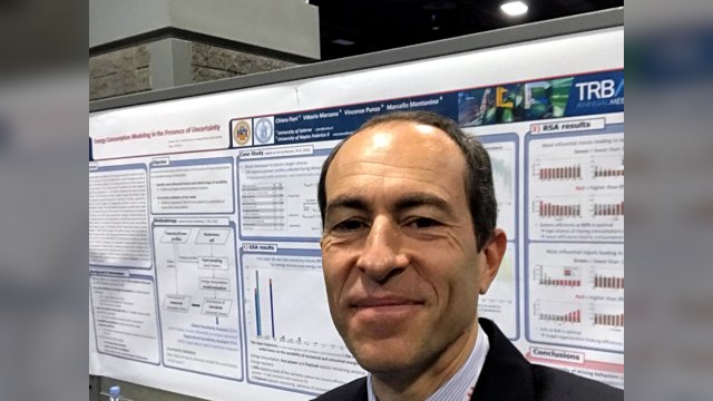 Vincenzo Punzo taking a selfie beside a TRB poster on energy consumption modelling under uncertainty