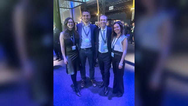 Vincenzo Punzo standing with three conference colleagues beside a large EUCAD display in Brussels