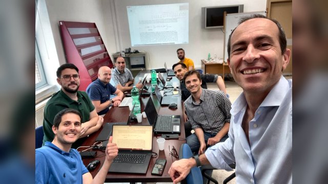 Marcello Montanino taking a group selfie with researchers from the Digital Mobility Lab and i4Driving international partners working around laptops