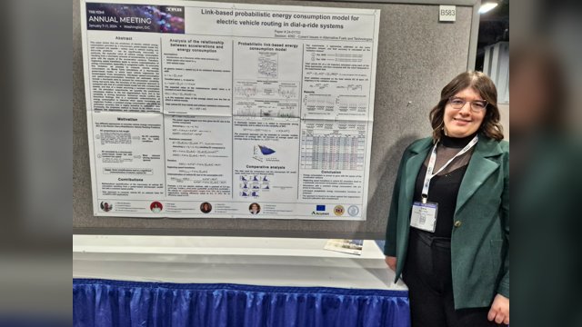 Ilaria Natale standing beside a poster on link-based probabilistic energy consumption for electric-vehicle routing