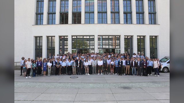 A large group of hEART 2025 participants posing outside a university building in Munich