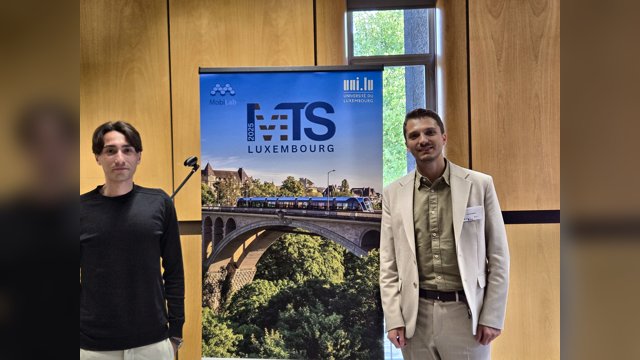 Giovanni Albano and Fabrizio Pelella standing beside the MT-ITS Luxembourg conference banner