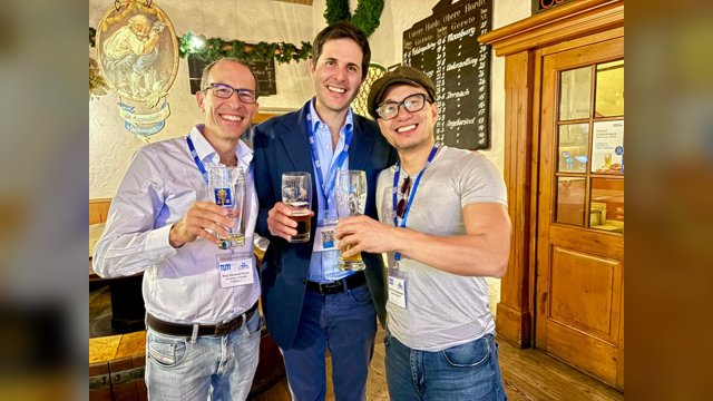 Vincenzo Punzo, Marcello Montanino and Dong Ngoduy smiling and raising their glasses during an informal ISTTT26 gathering in Munich