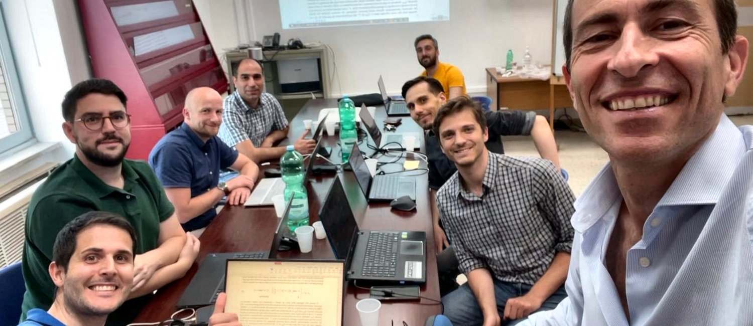 Marcello Montanino taking a group selfie with researchers from the Digital Mobility Lab and i4Driving international partners working around laptops